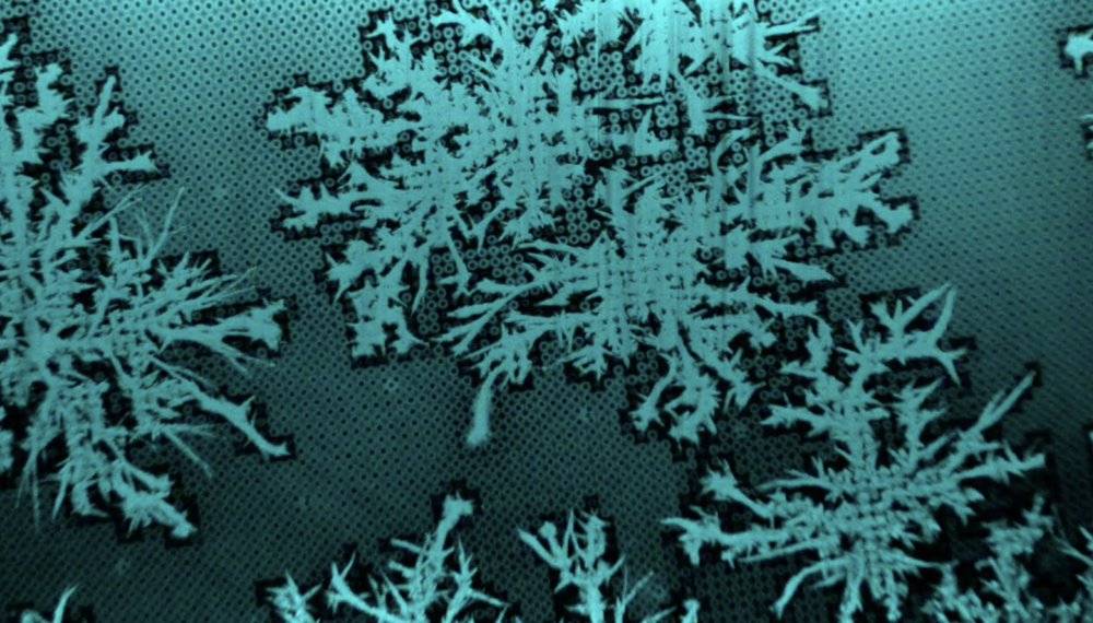 Frost Spreading and Pattern Formation on Microstructured Surfaces